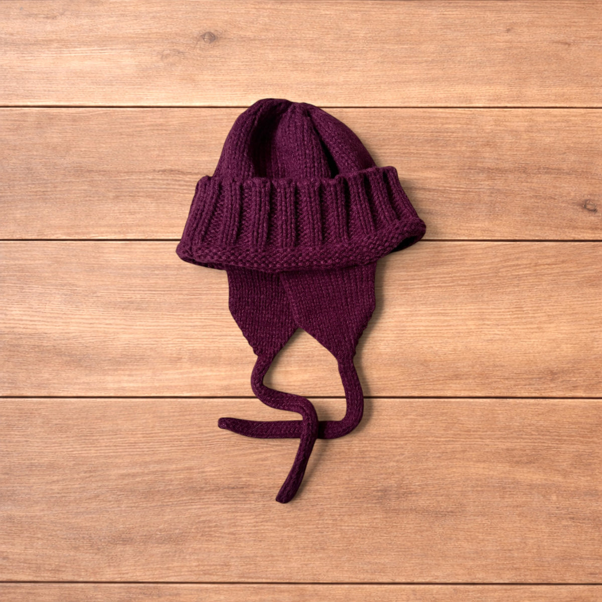 Vintage style dappy ear flap bobble hat in dark red.