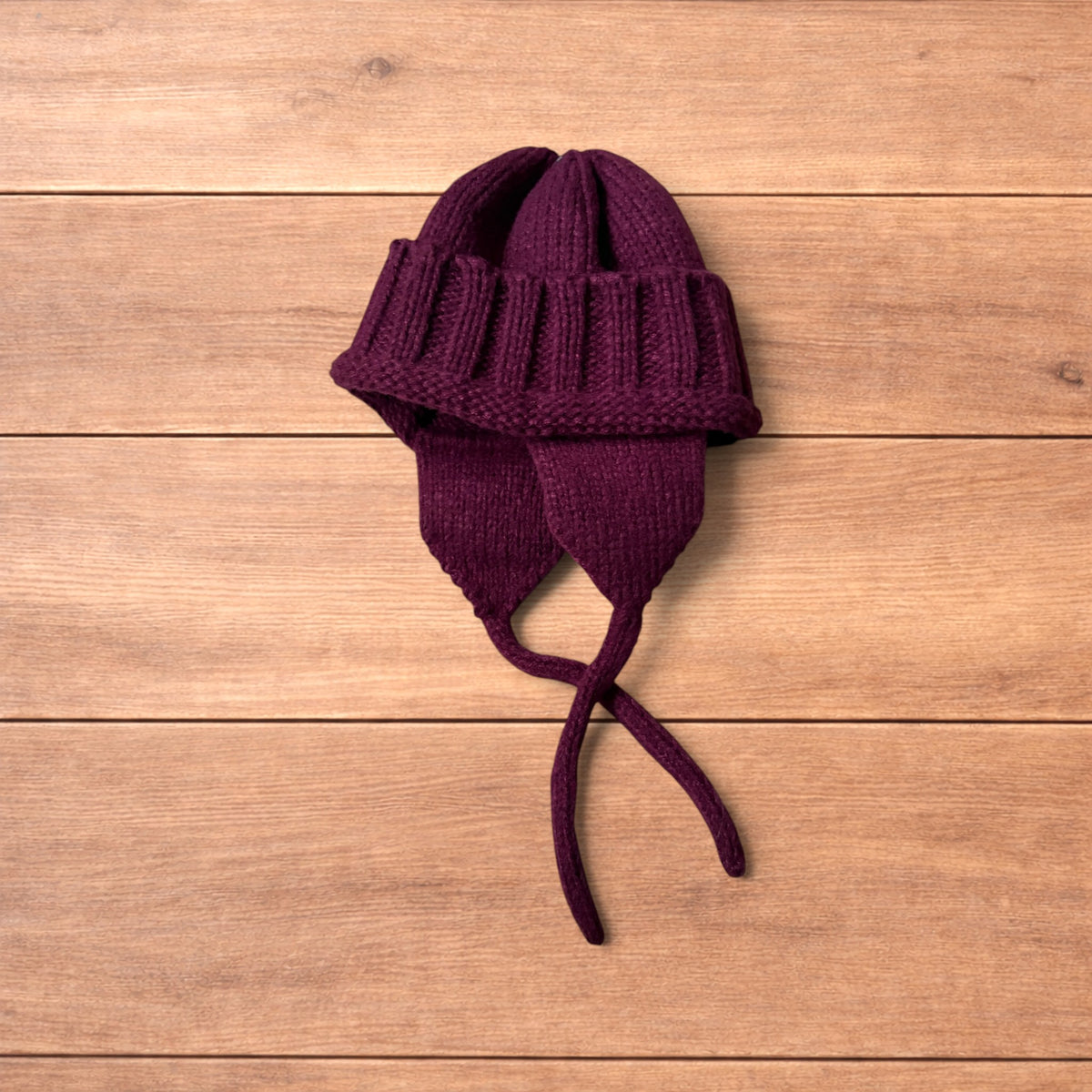 Vintage style dappy ear flap bobble hat in dark red.
