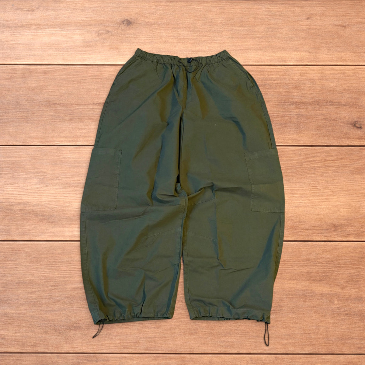 Baggy wide leg ripstop cargo trousers in khaki green with pockets, elasticated waist, and toggled hems.