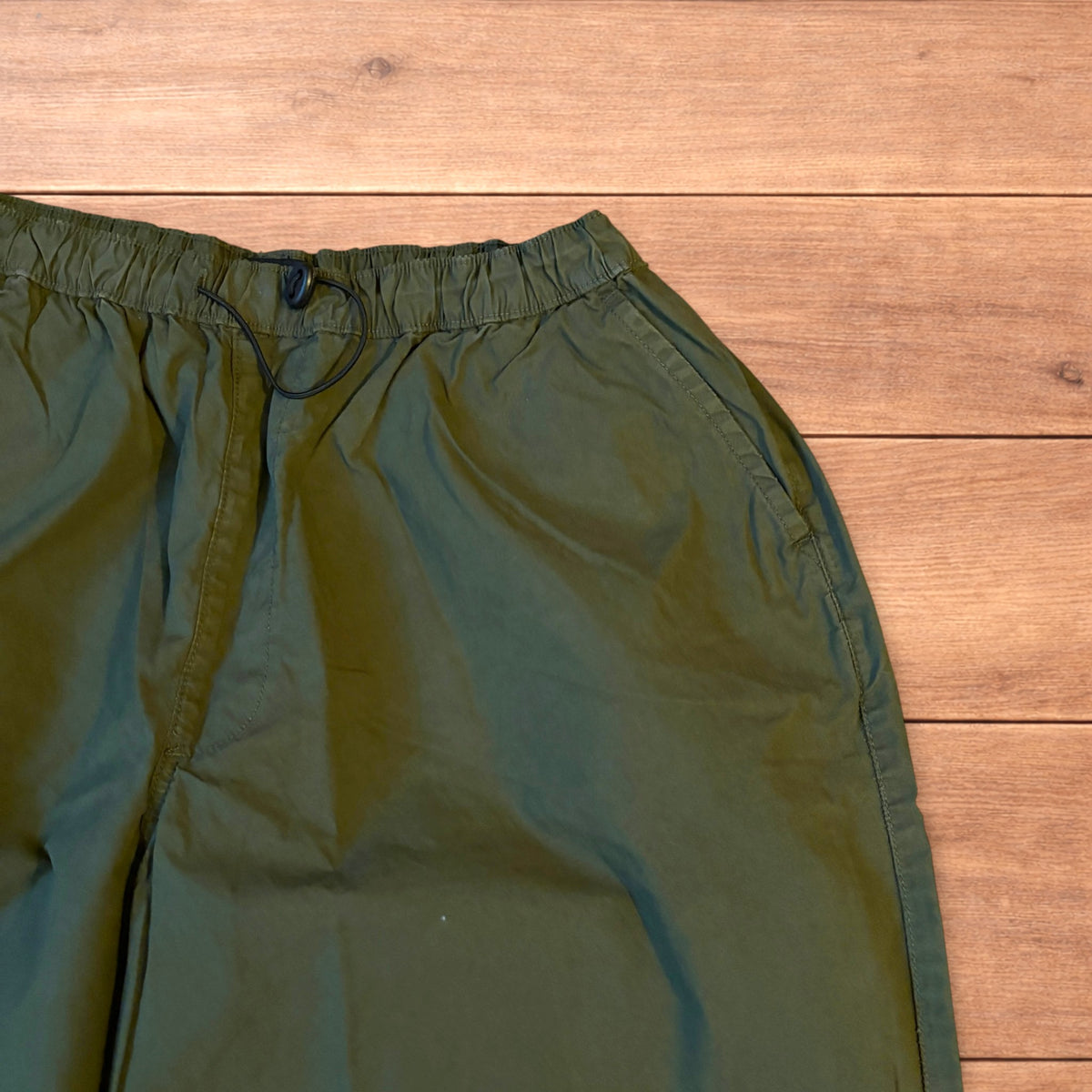 Baggy wide leg ripstop cargo trousers in khaki green with pockets, elasticated waist, and toggled hems.