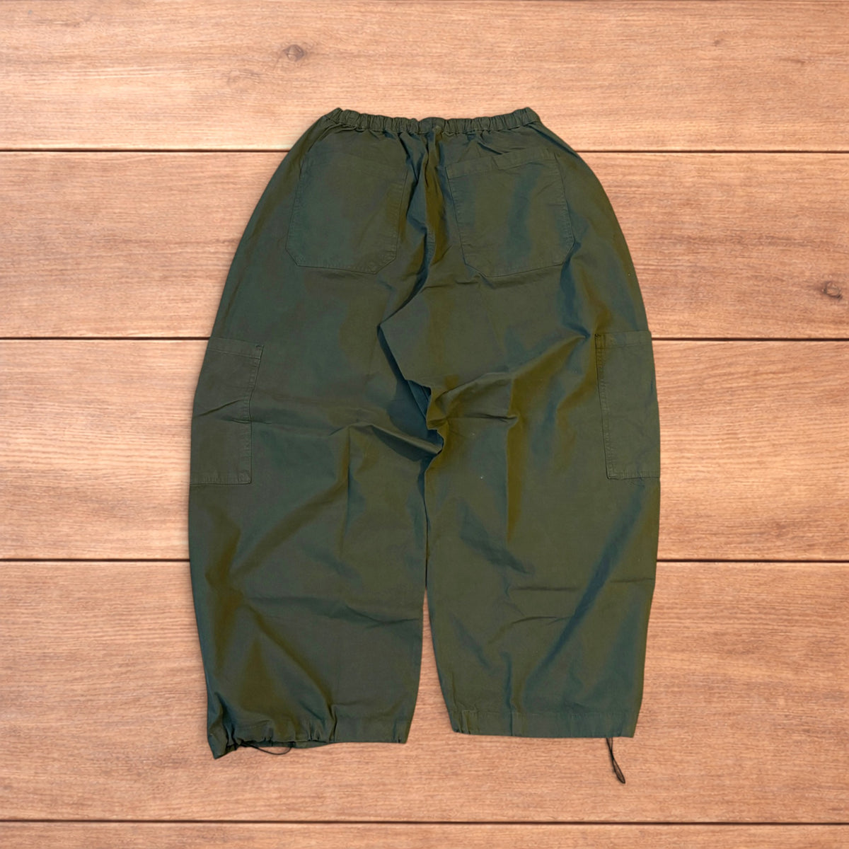 Baggy wide leg ripstop cargo trousers in khaki green with pockets, elasticated waist, and toggled hems.