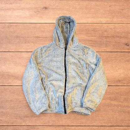 Light grey fluffy zip up hoodie jacket with full zip and hood displayed on wooden floor background