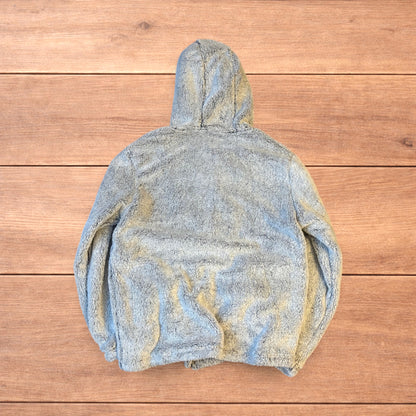 Light grey fluffy zip up hoodie jacket with full zip and hood displayed on wooden floor background