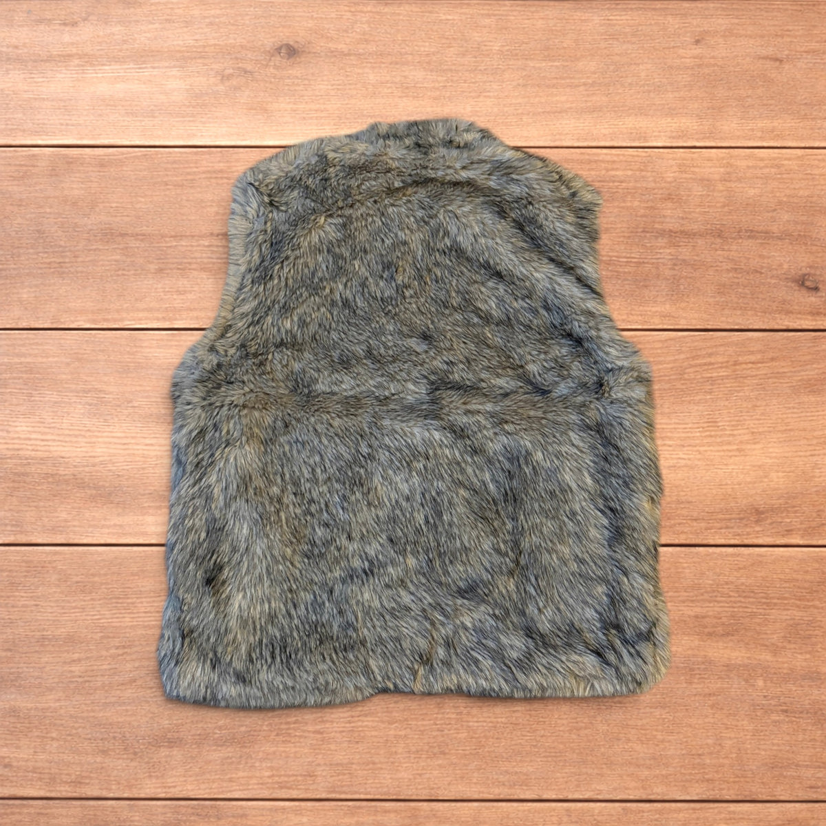 Beige brown faux fur gilet jacket with full zip on wooden surface