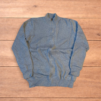 Grey vintage style knit track jacket with full zip and high neck laid flat on wooden surface.