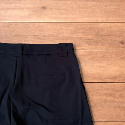 Black vintage style baggy wide leg tailored shorts laid flat on wooden floor showing front and back views