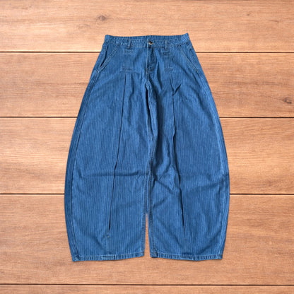 Vintage mid blue pinstripe baggy wide leg jeans with pleats laid flat on wooden surface