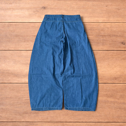 Vintage mid blue pinstripe baggy wide leg jeans with pleats laid flat on wooden surface