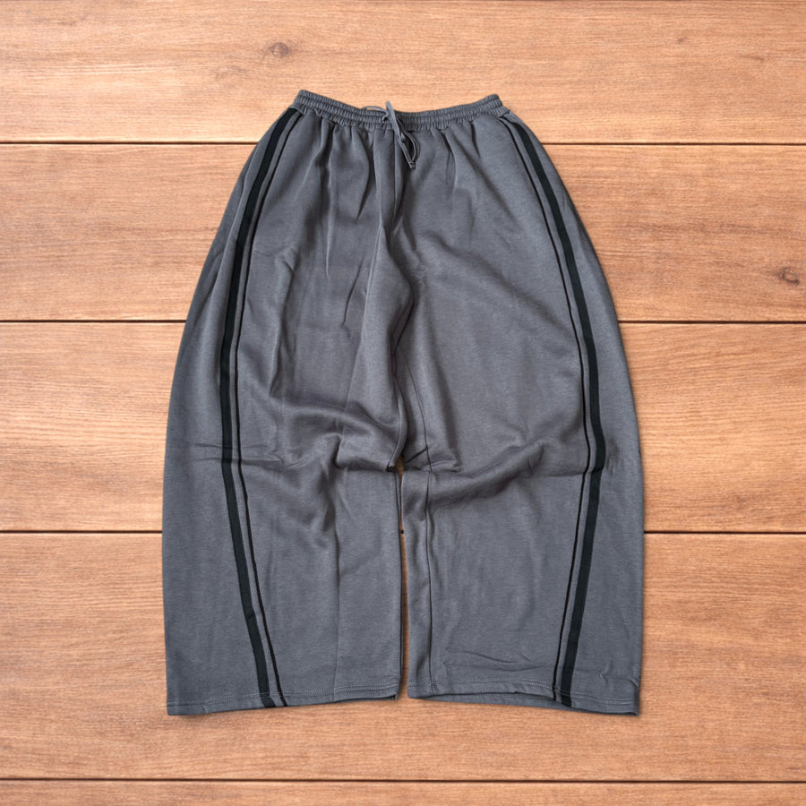 Dark grey super baggy wide leg Korean joggers with black side stripes laid flat showing front and back views.