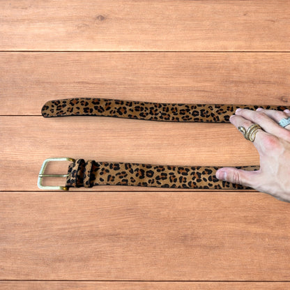 Vintage style faux leather western leopard cowboy belt with bronze trim.