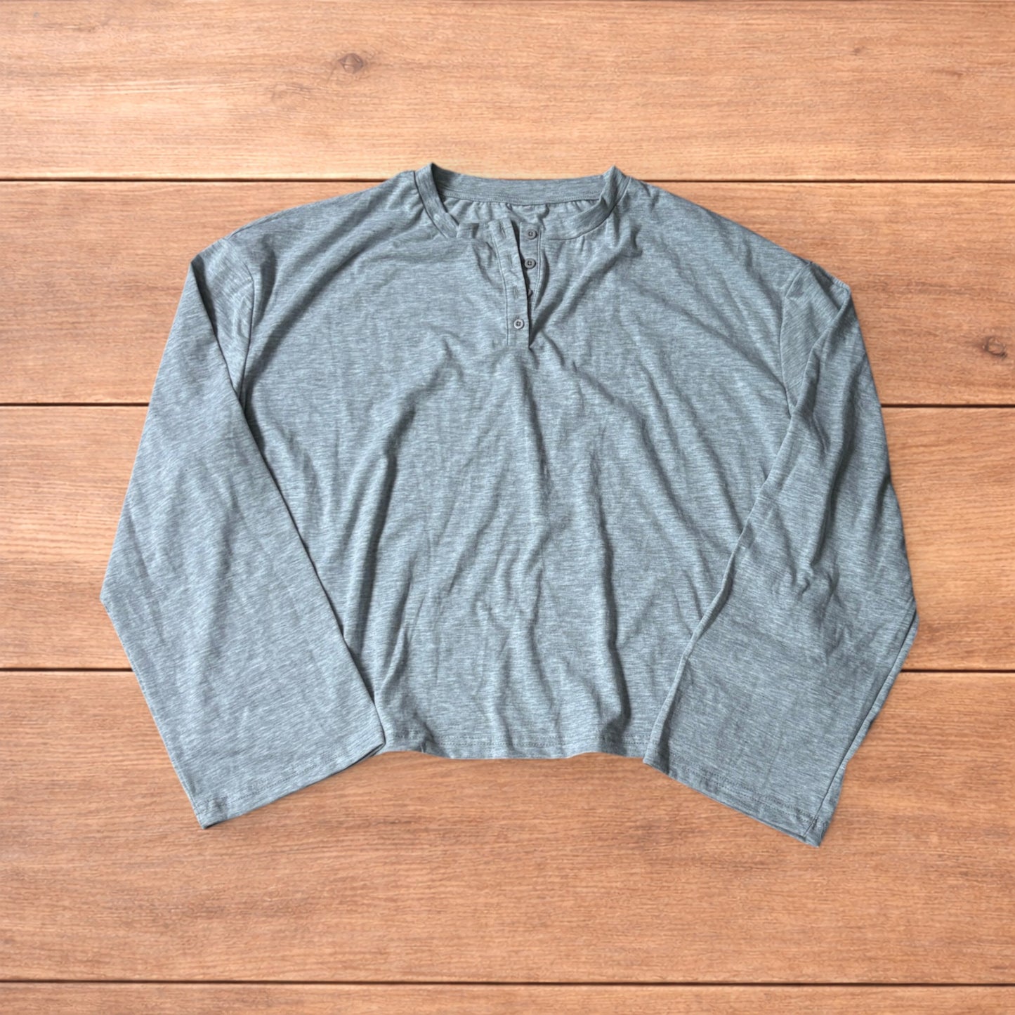 Relaxed fit henley long sleeve top in marl grey laid flat on wooden surface