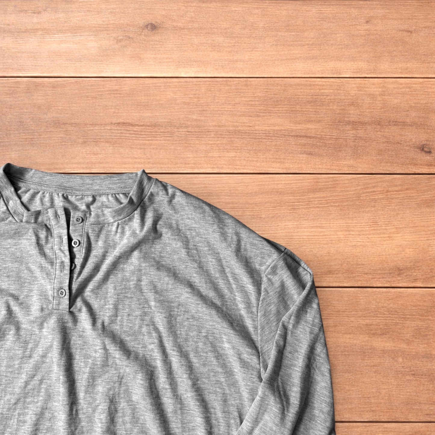 Relaxed fit henley long sleeve top in marl grey laid flat on wooden surface