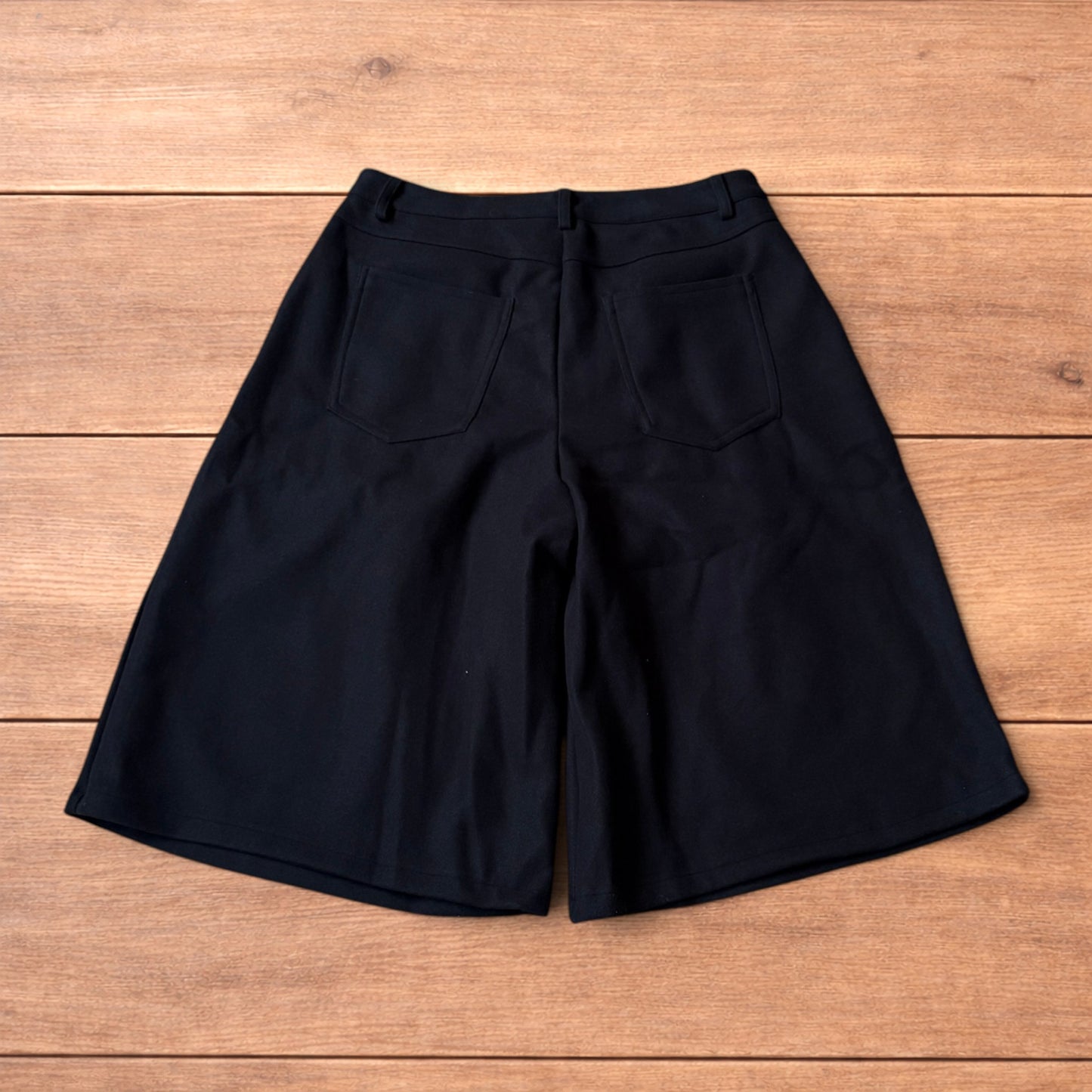 Vintage style baggy wide leg long tailored wool shorts in black.
