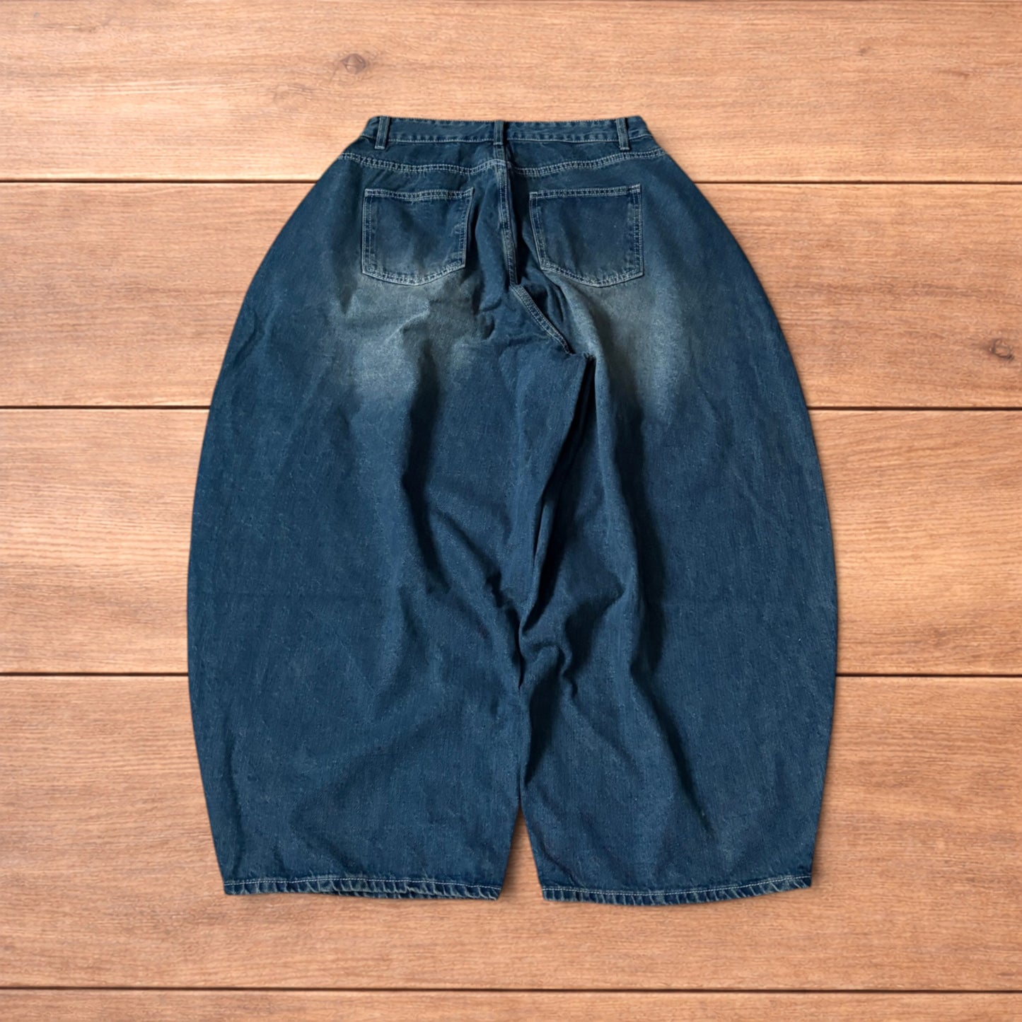 Super baggy wide leg balloon fit dark blue jeans laid flat showing front, back and pockets