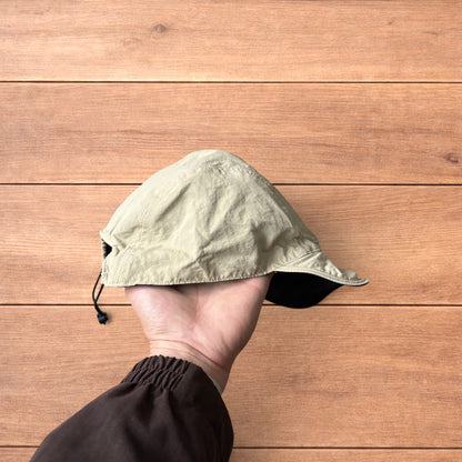 Lightweight reversible military pilot trapper hat in cream/black.