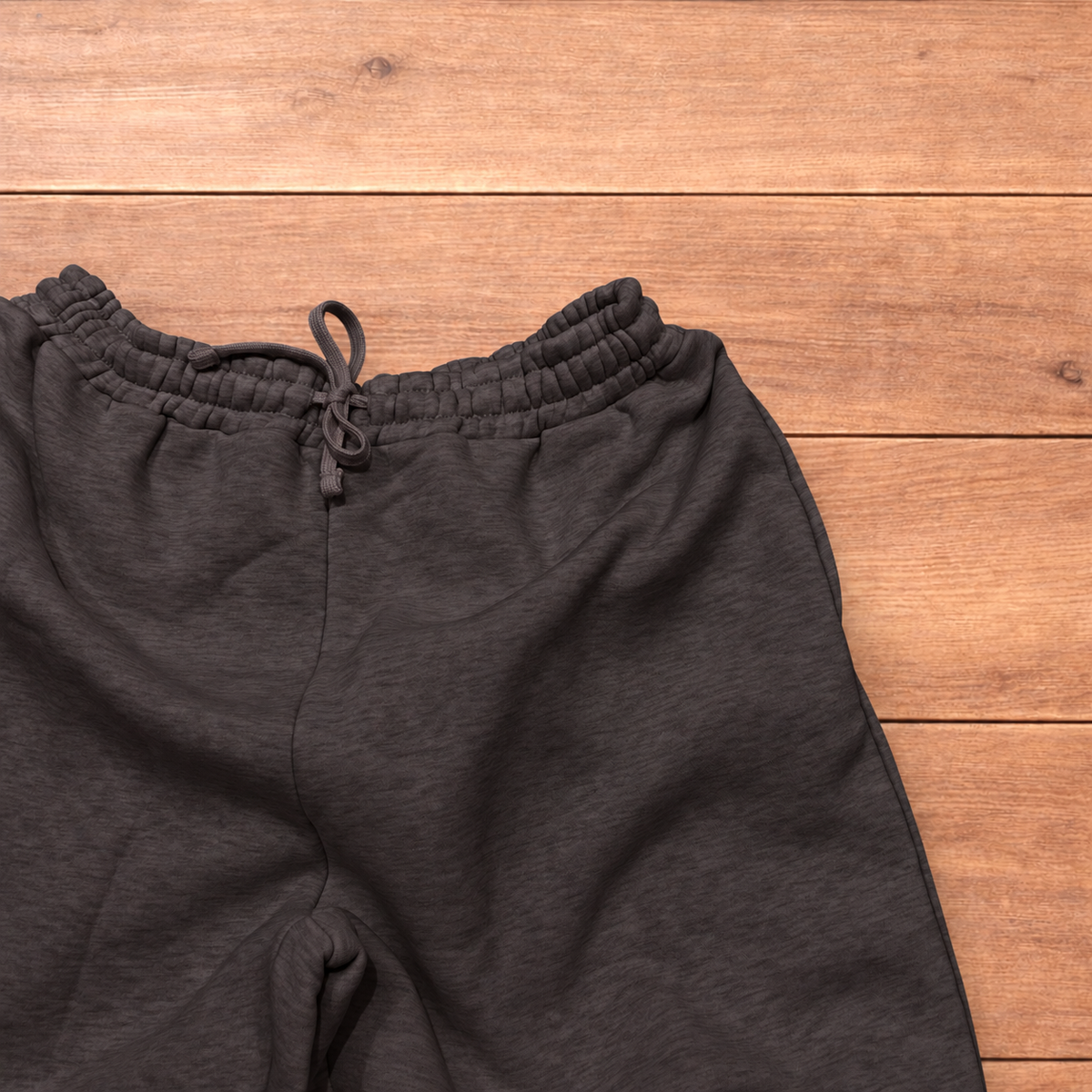 Navy baggy joggers featuring a white and burgundy check pattern laid flat on wood surface.