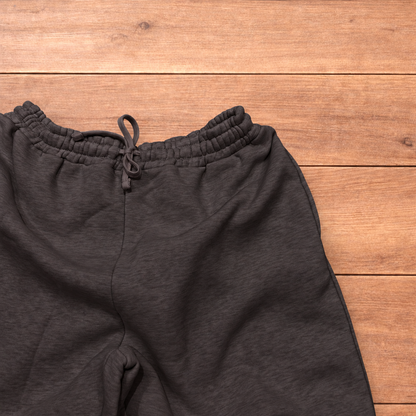 Navy baggy joggers featuring a white and burgundy check pattern laid flat on wood surface.