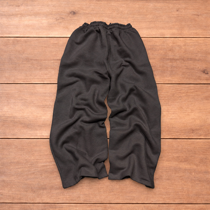 Navy baggy joggers featuring a white and burgundy check pattern laid flat on wood surface.