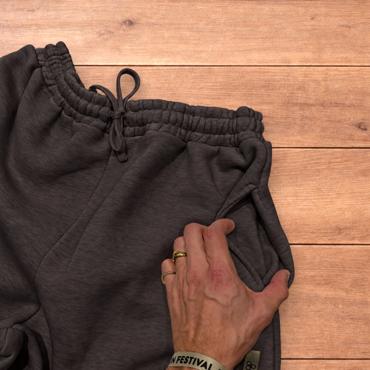 Navy baggy joggers featuring a white and burgundy check pattern laid flat on wood surface.