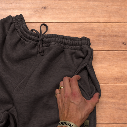 Navy baggy joggers featuring a white and burgundy check pattern laid flat on wood surface.