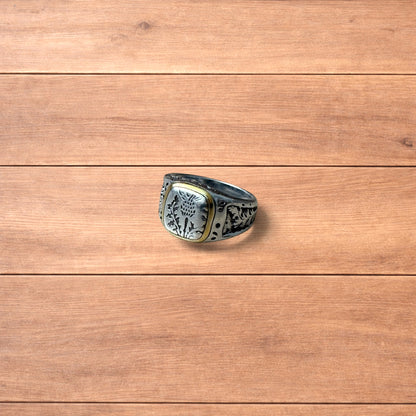 Silver chunky ring with Japanese nature design and gold trim worn on hand.