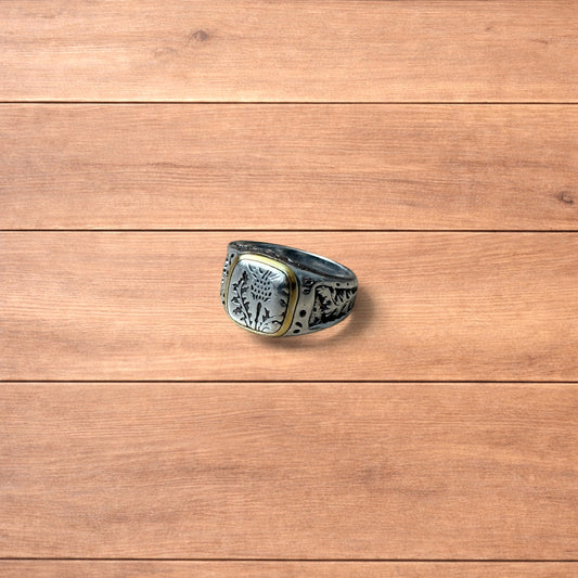Silver chunky ring with Japanese nature design and gold trim worn on hand.