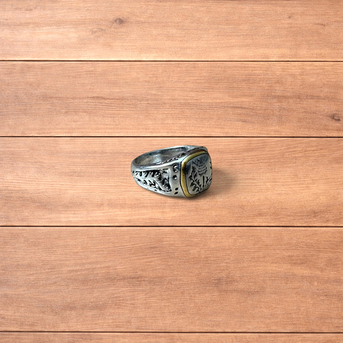 Silver chunky ring with Japanese nature design and gold trim worn on hand.